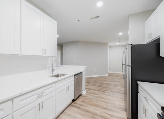 a white kitchen with white cabinets and a black refrigerator at The Lena, Raritan, NJ 08869