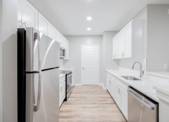 a white kitchen with stainless steel appliances and white cabinets at The Lena, Raritan, NJ 08869