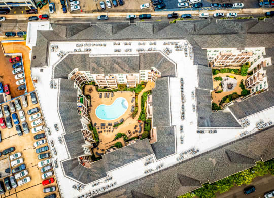 an aerial view of a building with a pool and parking lot at Metro 303, Hempstead, NY