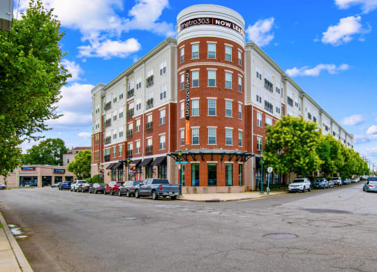 a building on the corner of a street with cars parked in front of it at Metro 303, Hempstead, NY 11550