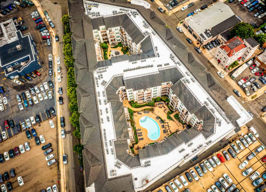 an aerial view of an apartment complex with a swimming pool and parking lot at Metro 303, Hempstead New York