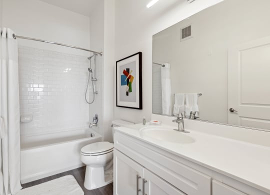 a bathroom with a bathtub toilet and sink at Metro 303, Hempstead, NY 11550
