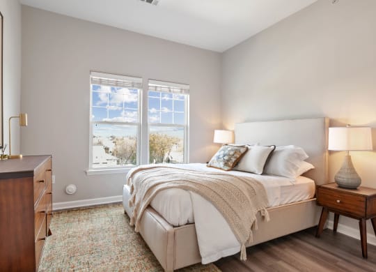 a bedroom with a bed and two windows at Metro 303, Hempstead, NY