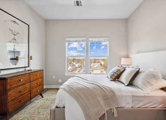 a bedroom with a bed and a dresser at Metro 303, Hempstead