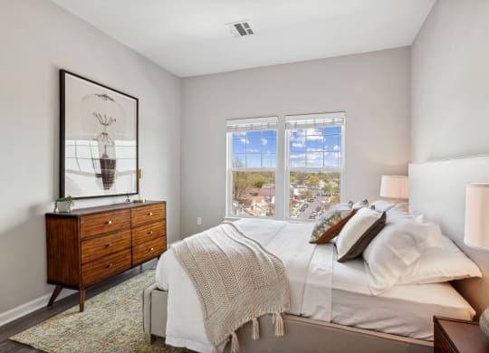 a bedroom with a bed and a dresser at Metro 303, Hempstead, NY