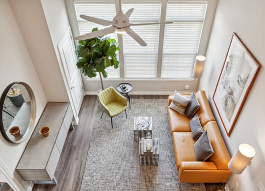 an overhead view of a living room with a brown couch and yellow chair at Metro 303, Hempstead, NY