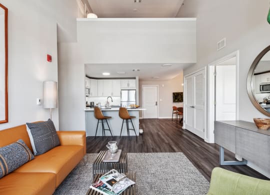 a living area with a couch coffee table and a kitchen in the background at Metro 303, Hempstead, 11550