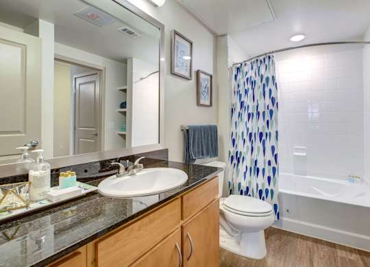 A bathroom with a white toilet, sink, and shower at Regatta Sloans Lake Apartments, Colorado, 80204