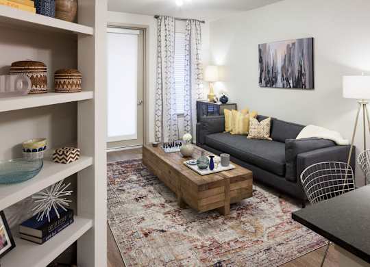 A living room with a grey couch and a wooden coffee table at Regatta Sloans Lake Apartments, Denver, CO, 80204