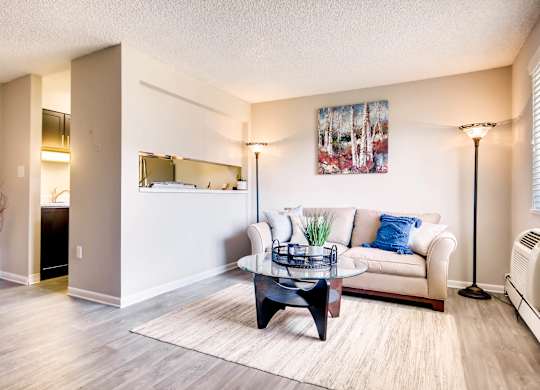 A living room with a white couch and a coffee table at Mountain Vista Apartments, Lakewood, CO