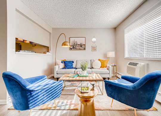 A living room with a blue chair and a white couch at Mountain Vista Apartments, Colorado, 80228