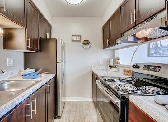 A kitchen with a stove top oven and a refrigerator at Mountain Vista Apartments, Lakewood