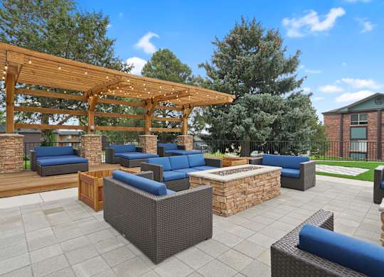 A patio with a wooden pergola and blue cushioned furniture at Mountain Vista Apartments, Colorado, 80228