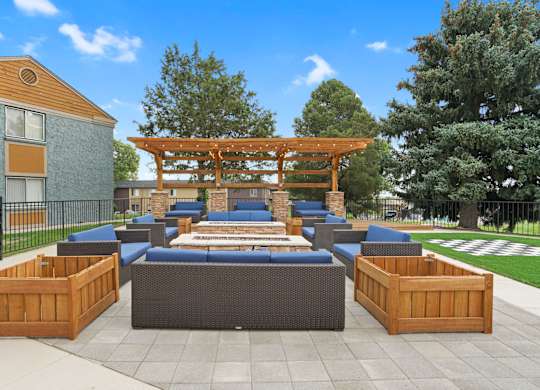 A wooden pergola is situated above a blue couch and a wooden table at Mountain Vista Apartments, Lakewood