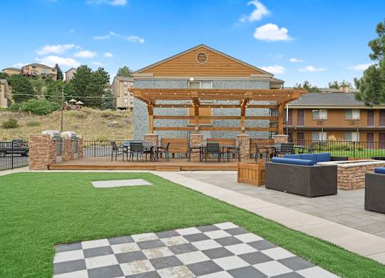 A large wooden building with a checkered pattern on the ground in front of it at Mountain Vista Apartments, Lakewood, Colorado