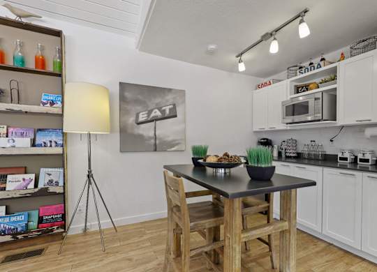 A kitchen with a table and chairs in the middle of it at The Ranch at Bear Creek Apartments, Lakewood, CO