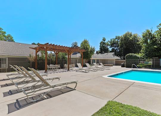 A pool area with sun loungers and a pergola at The Ranch at Bear Creek Apartments, Lakewood, 80227