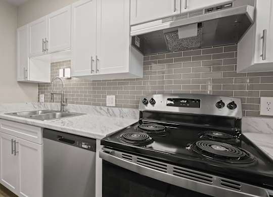 A kitchen with a stove, sink, and cabinets at The Ranch at Bear Creek Apartments, Lakewood, 80227