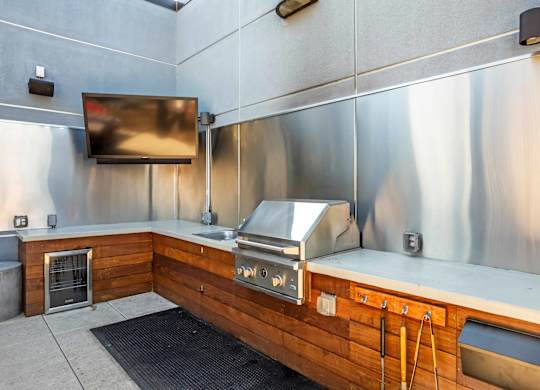 A modern kitchen with stainless steel appliances and wooden accents at Regatta Sloans Lake Apartments, Colorado
