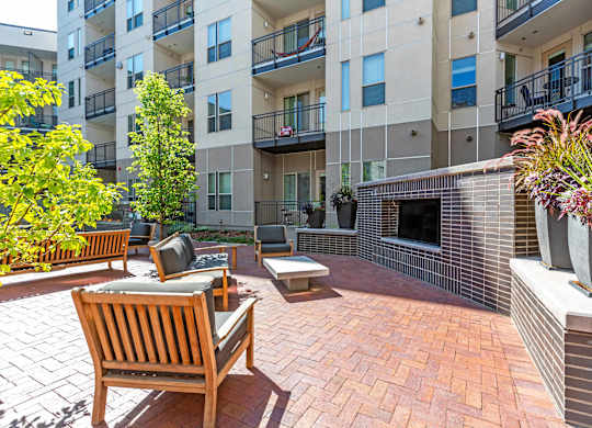 A patio with a bench and a fireplace in front of a building at Regatta Sloans Lake Apartments, Denver, 80204