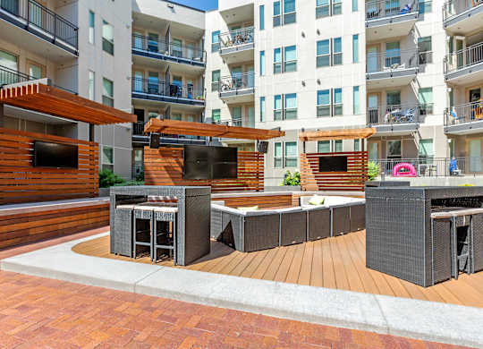 A modern outdoor seating area with a wooden deck and a television at Regatta Sloans Lake Apartments, Denver, CO, 80204
