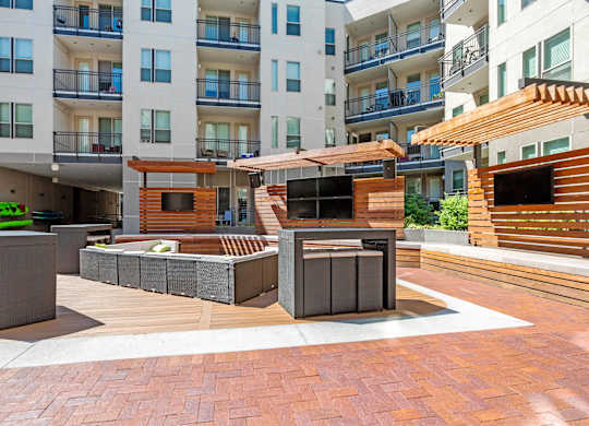 A modern outdoor seating area with wooden and concrete furniture at Regatta Sloans Lake Apartments, Colorado