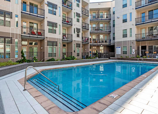A swimming pool in front of apartment buildings at Regatta Sloans Lake Apartments, Denver, CO, 80204
