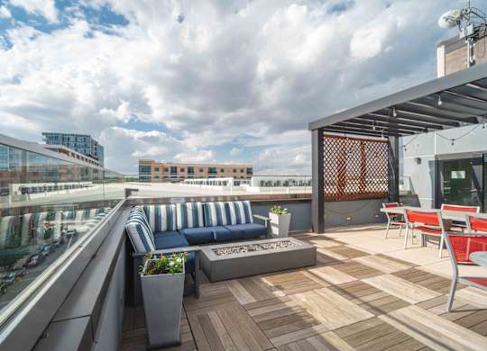 A rooftop patio with a blue couch and wooden deck at Regatta Sloans Lake Apartments, Colorado, 80204