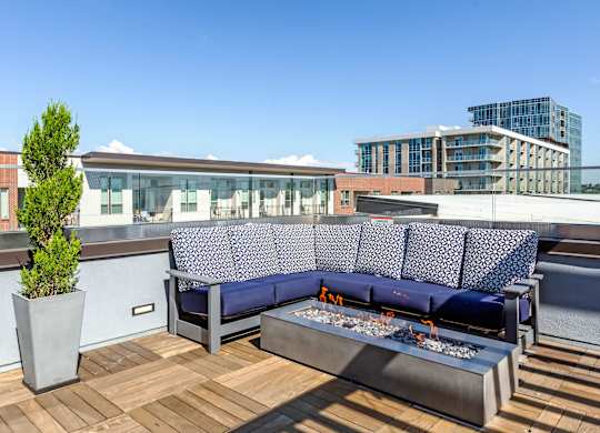 A blue couch with a white patterned cushion is on a wooden deck at Regatta Sloans Lake Apartments, Denver, CO, 80204
