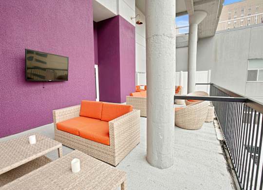 A patio with a purple wall and a television.