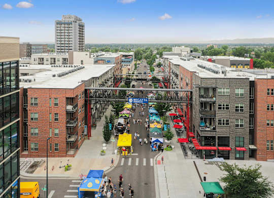 A busy street scene with people walking and cars driving at Regatta Sloans Lake Apartments, Denver, CO