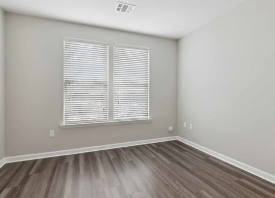 a bedroom with hardwood floors and a large window at Metro 303, Hempstead
