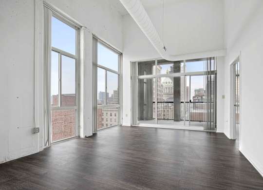 A large empty room with wooden floors and white walls.