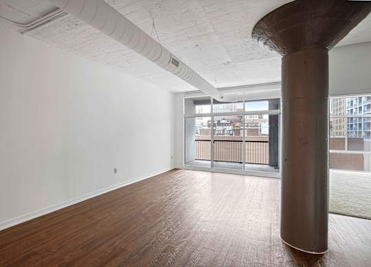 A room with a wooden floor and a large column.