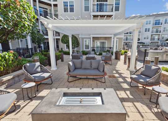 Patio with a white pergola and sitting area at West 130, New York , 11552