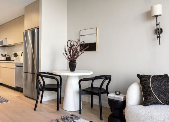 a living room with a small table and a kitchen at The Paxton, Brooklyn, 11201