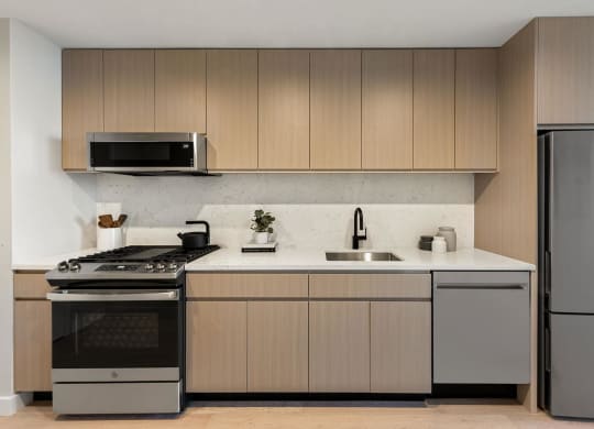 a kitchen with wooden cabinets and stainless steel appliances at The Paxton, New york