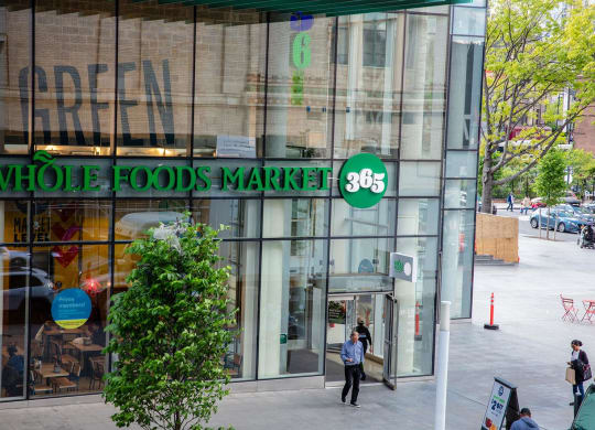 the front of a whole foods market store on a city street at The Paxton, New york