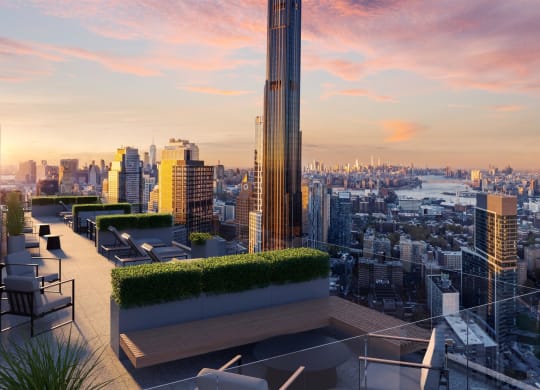 a rooftop terrace with a view of the city and a sunset at The Paxton, New york