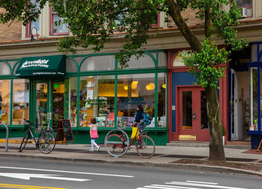 a man walking down the street with a bike at The Paxton, Brooklyn, New York