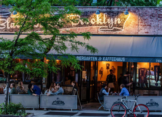 people sitting at tables outside of a restaurant at The Paxton, Brooklyn, 11201