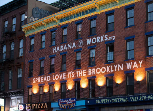 a building with a sign that reads spread love its the way at The Paxton, Brooklyn, NY