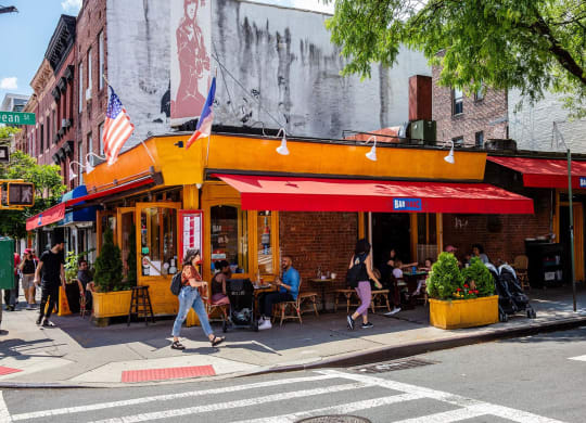 people walking down the street in front of a restaurant at The Paxton, Brooklyn, NY 11201