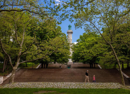 a man and two children standing on a wall in front of a lighthouse at The Paxton, Brooklyn, New York