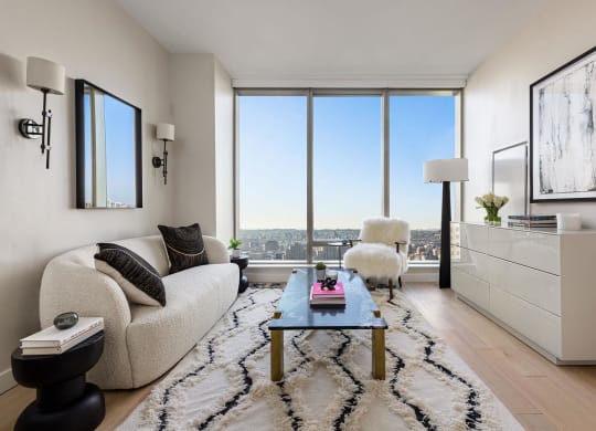 a living room with a view and a couch and a table at The Paxton, New york