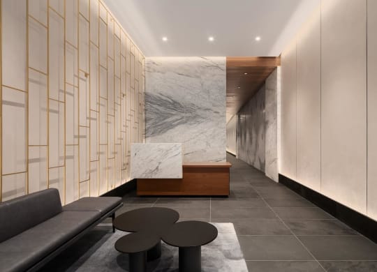 a lobby with couches and tables and a marble wall at The Paxton, Brooklyn, 11201