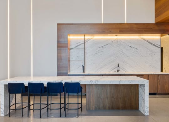 a kitchen with a marble counter top and blue chairs at The Paxton, Brooklyn, New York