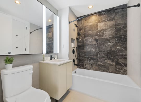 a bathroom with a white toilet and a shower and a sink at The Paxton, Brooklyn
