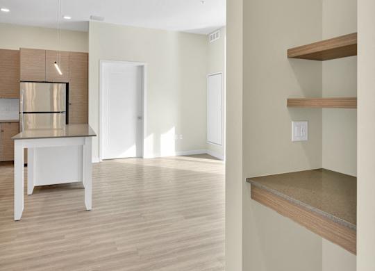 A kitchen with a white table and wooden shelves.
