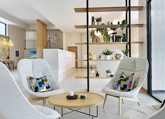 A modern living room with a white chair and a wooden table.